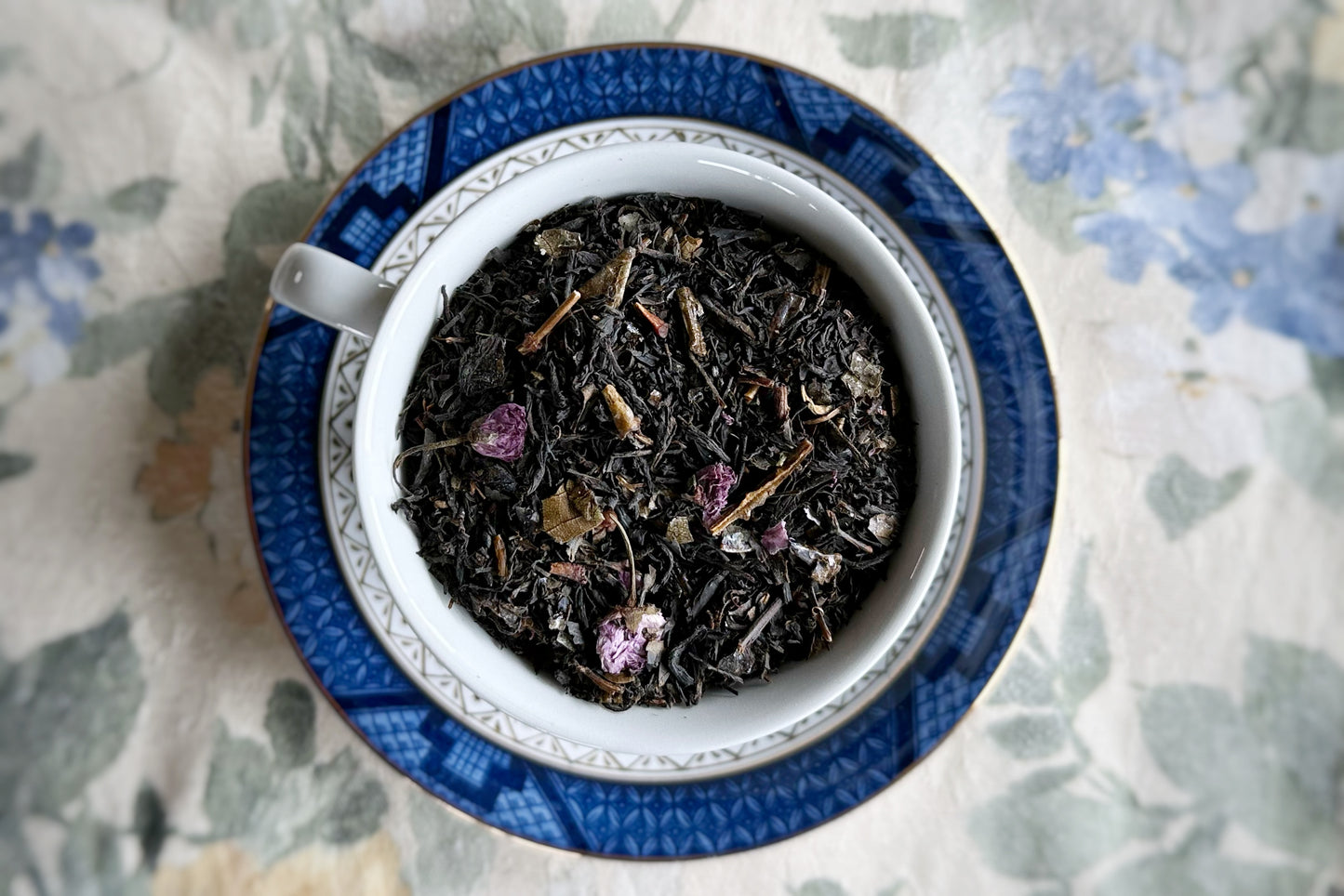 Teacup full of black tea and cherry blossoms