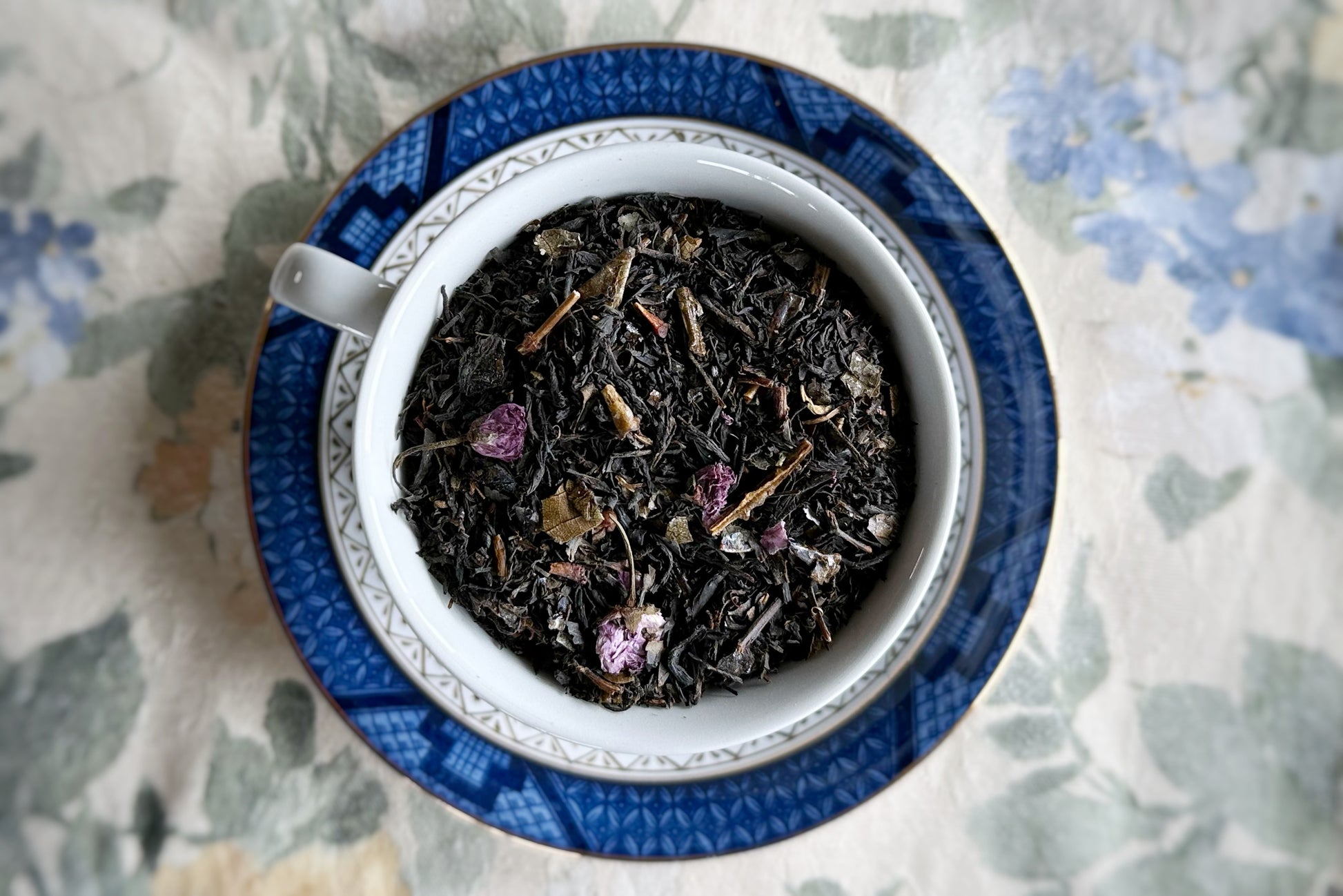 Teacup full of black tea and cherry blossoms