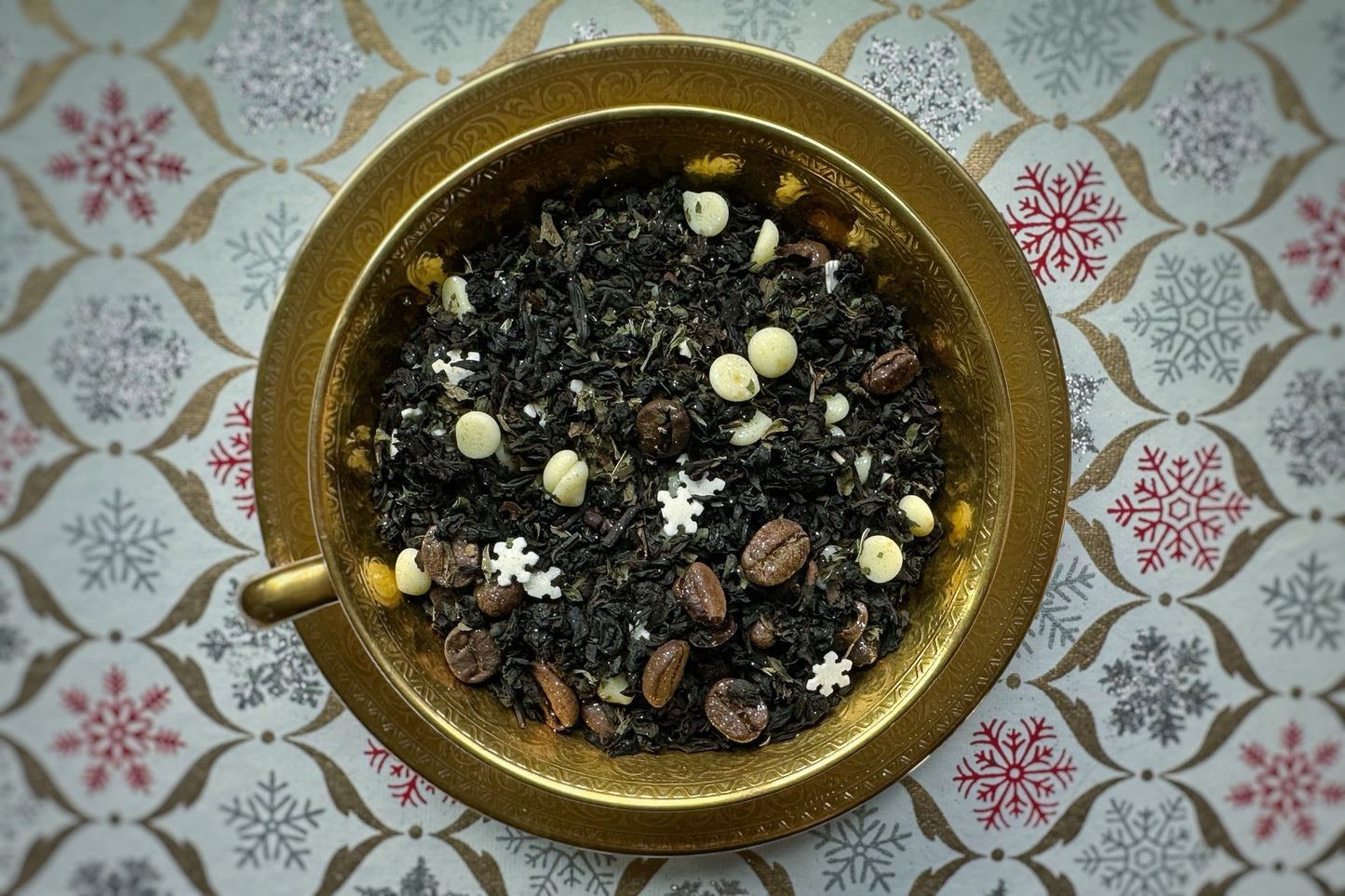 Tea leaves in a gilded teacup on a patterned surface