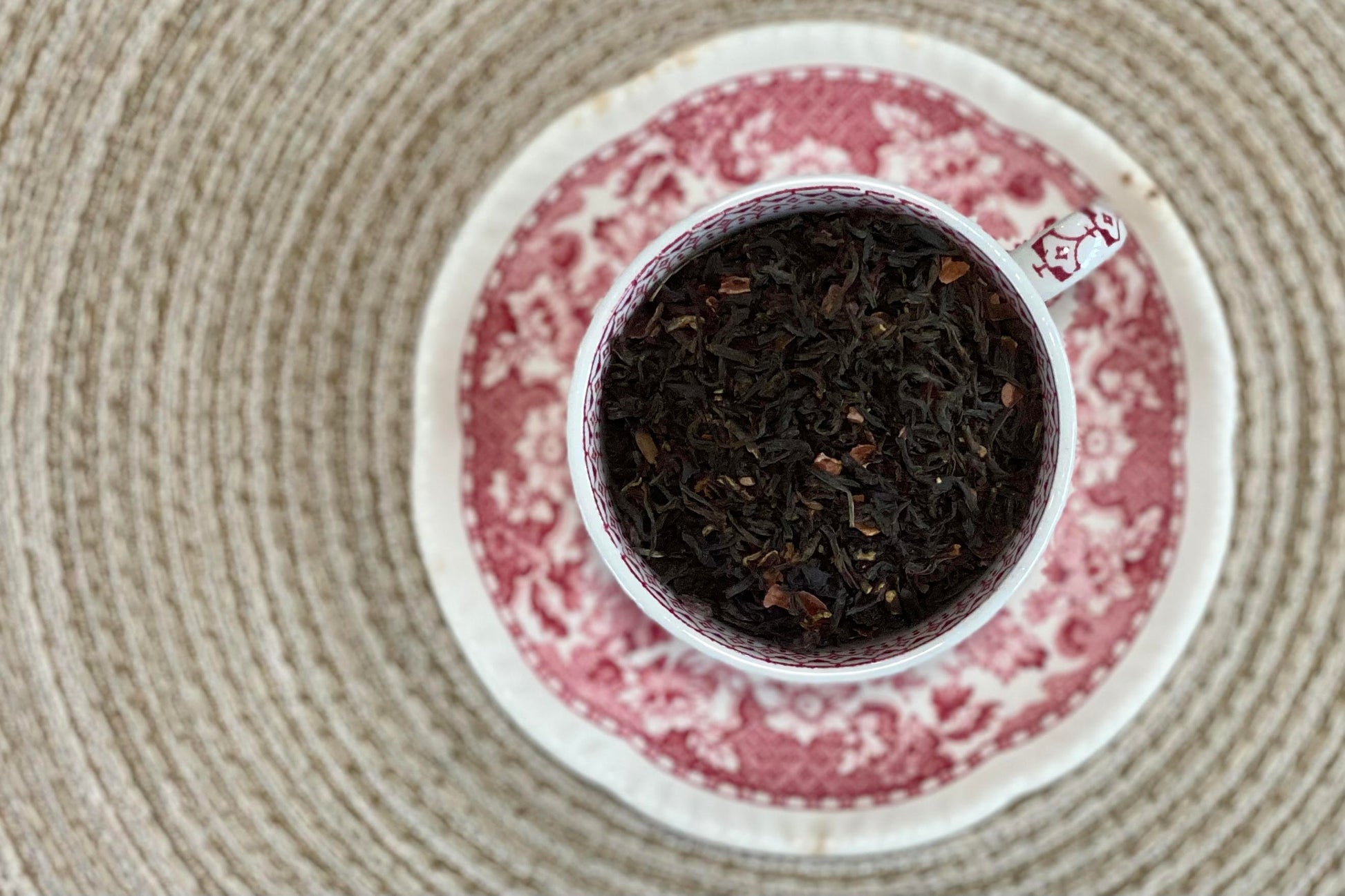 Teacup full of black tea with cacao nib