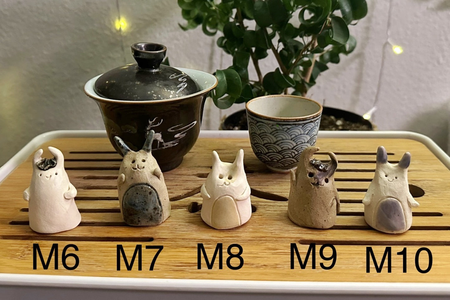 Five slug demon lookin tea pets on a bamboo tea tray
