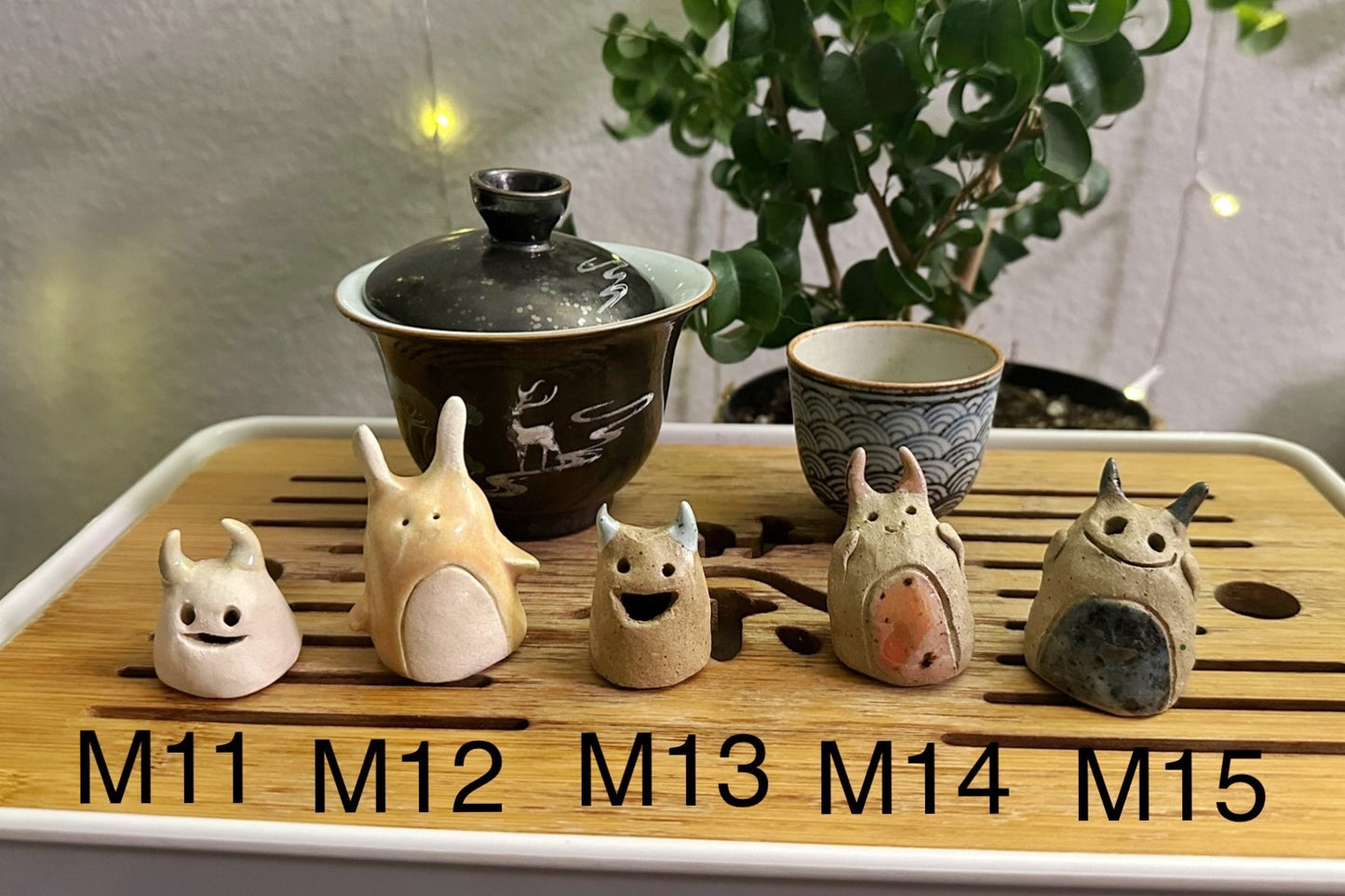 Five slug demon lookin tea pets on a bamboo tea tray