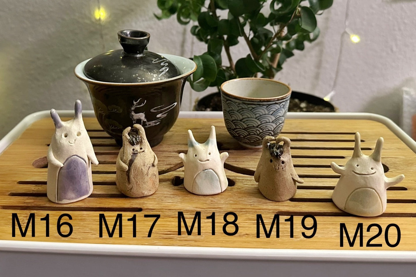 Five slug demon lookin tea pets on a bamboo tea tray