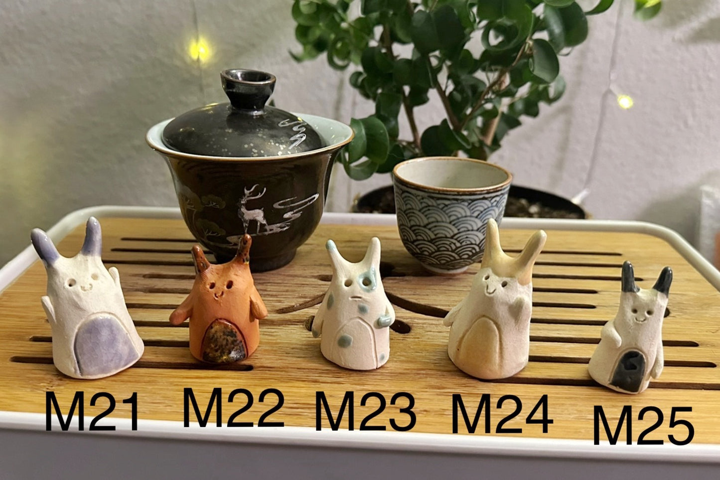 Five slug demon lookin tea pets on a bamboo tea tray