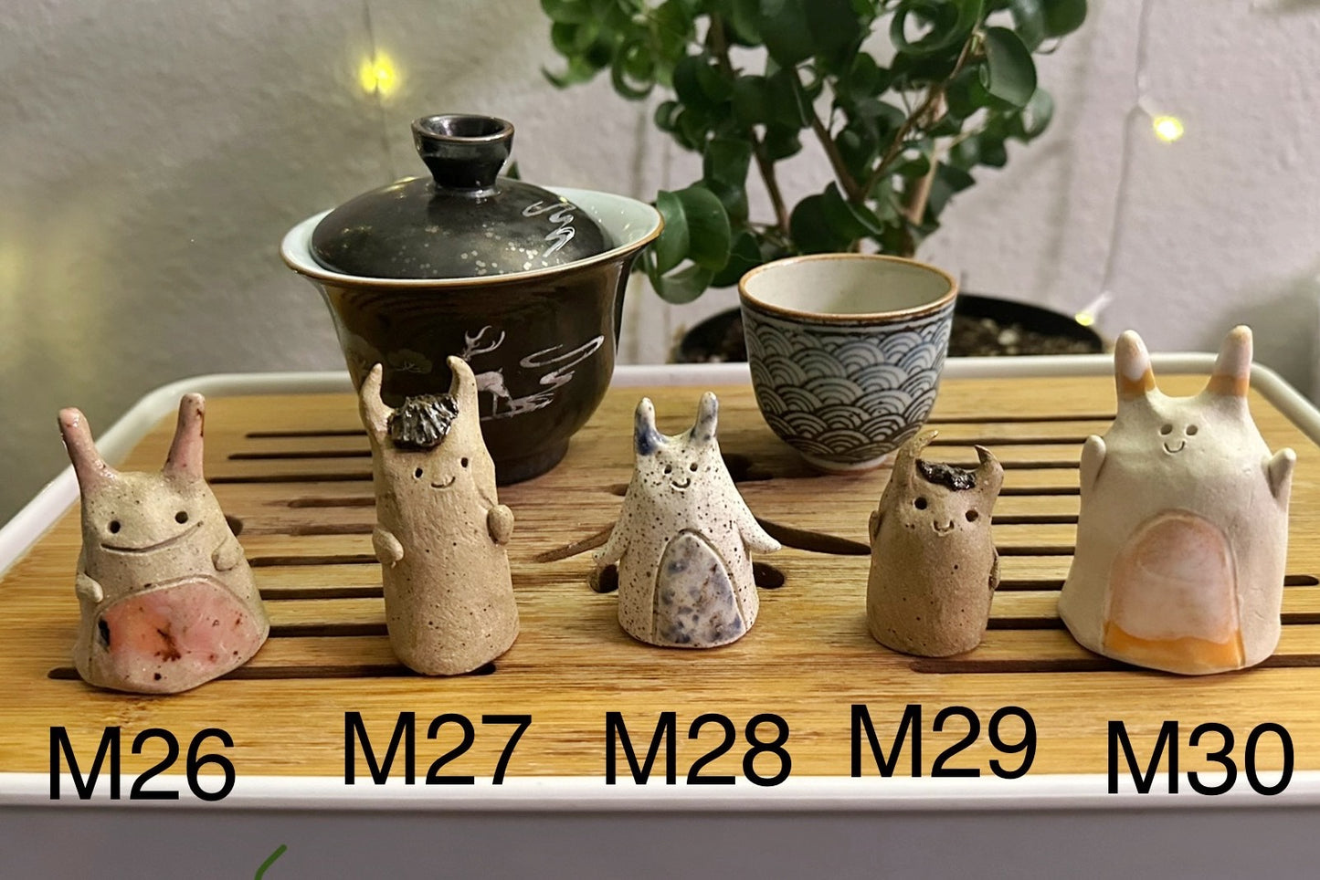 Five slug demon lookin tea pets on a bamboo tea tray