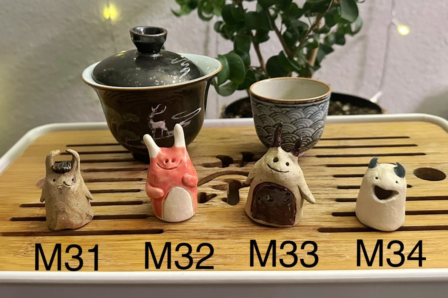 Four slug demon lookin tea pets on a bamboo tea tray