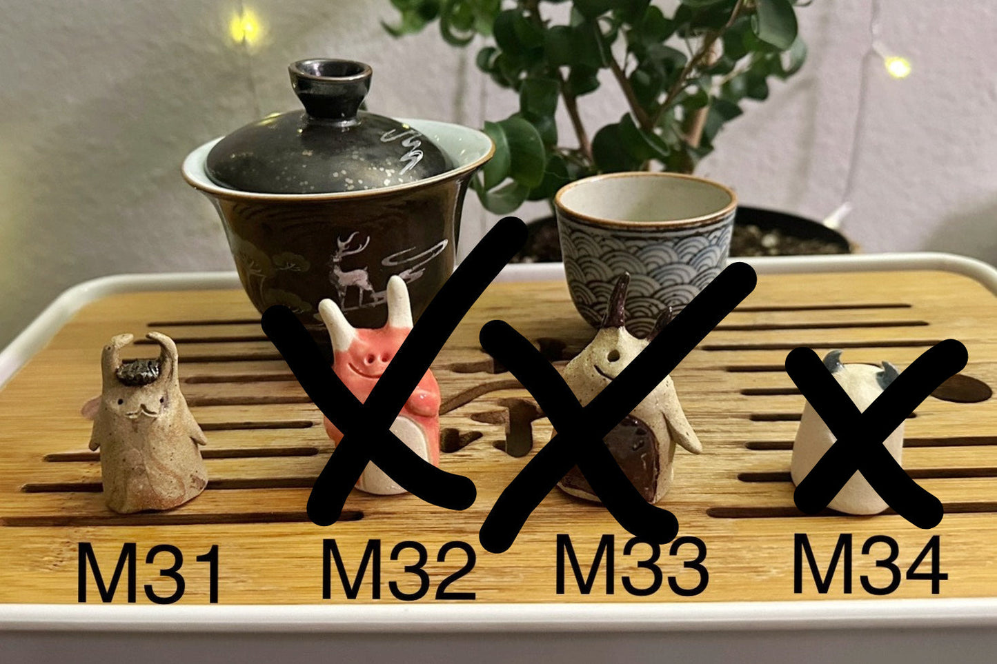 Four slug demon lookin tea pets on a bamboo tea tray