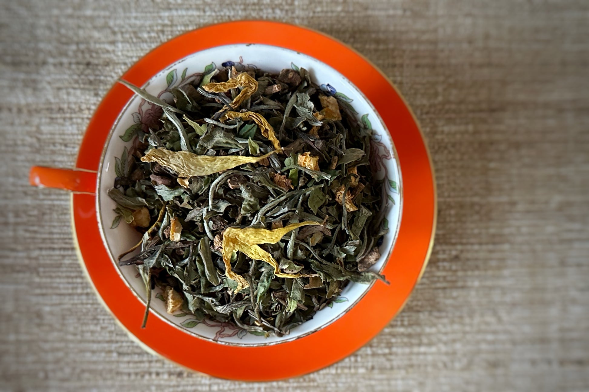 teacup full of white tea with sunflower petals