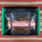 Seven Avatar-themed tea samples in a black box on a colorful cloth