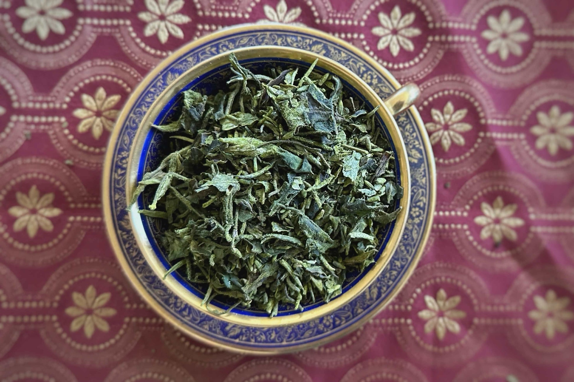 Teacup full of matcha-dusted white tea with lavender