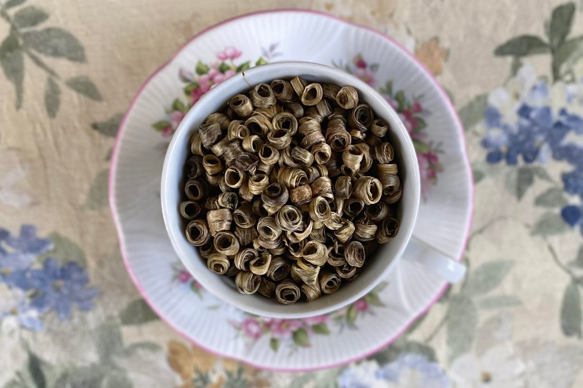 teacup full of silver tea leaf spirals