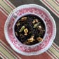 Teacup full of black tea, spices and apple pieces