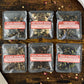 Six packages of tea on a wooden surface with visible text on labels