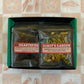 Two tea packages labeled 'Hearthfire' and 'Robot's Garden' on a patterned surface.