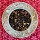 teacup full of hibiscus, citrus peel, rose and honey granule