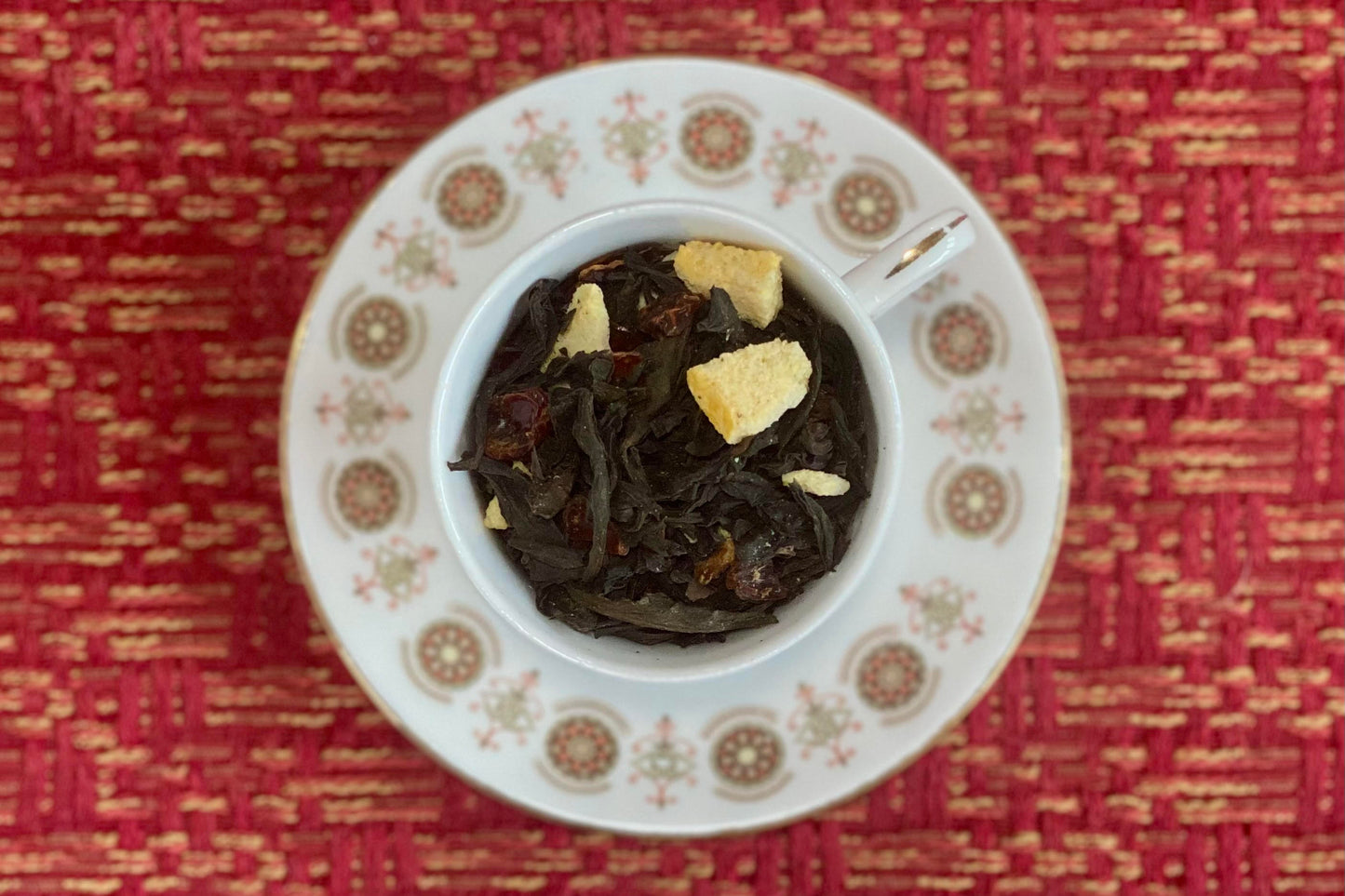 teacup full of dark oolong leaves and peach pieces