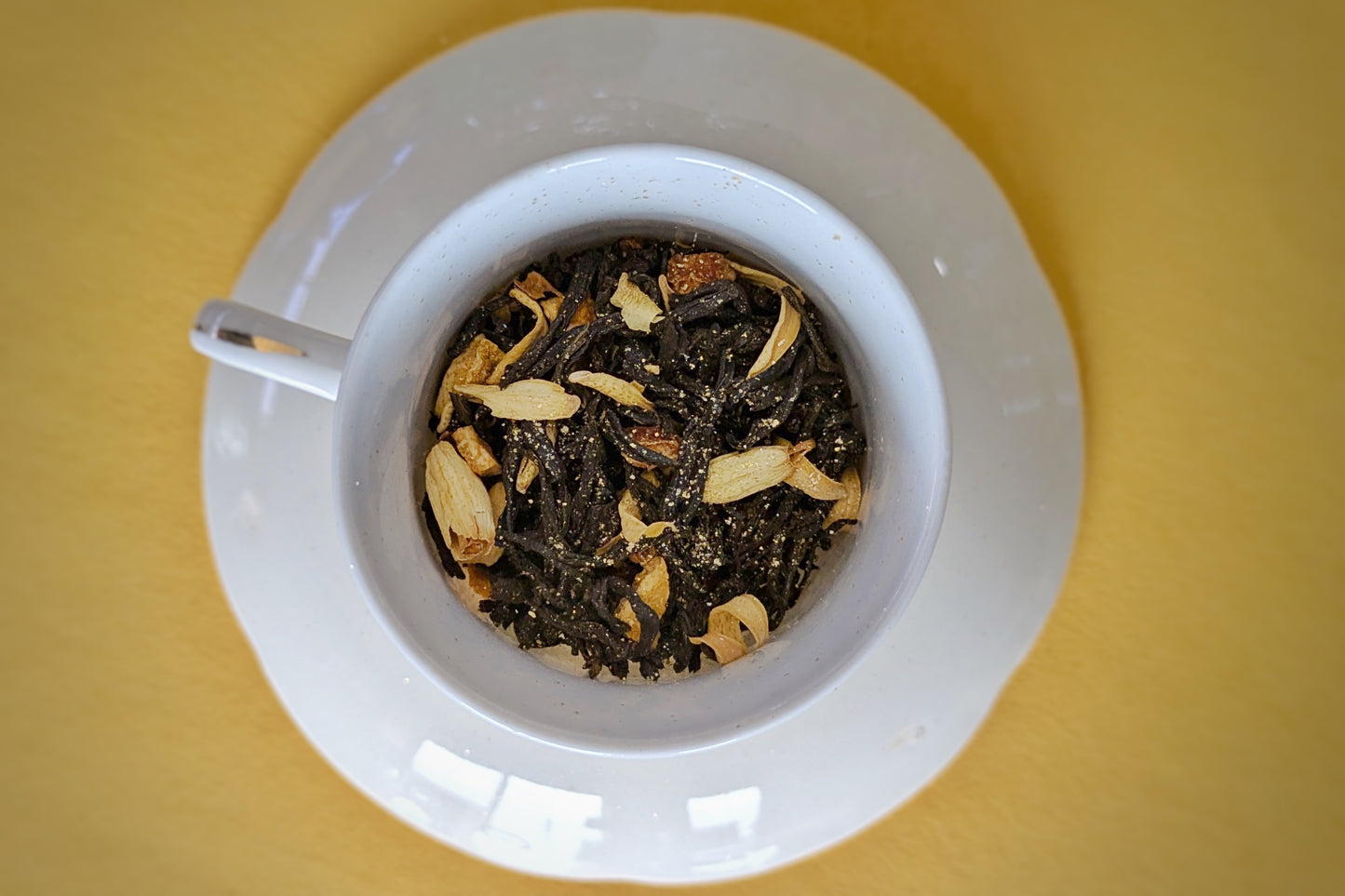 teacup full of black tea and orange blossom petal