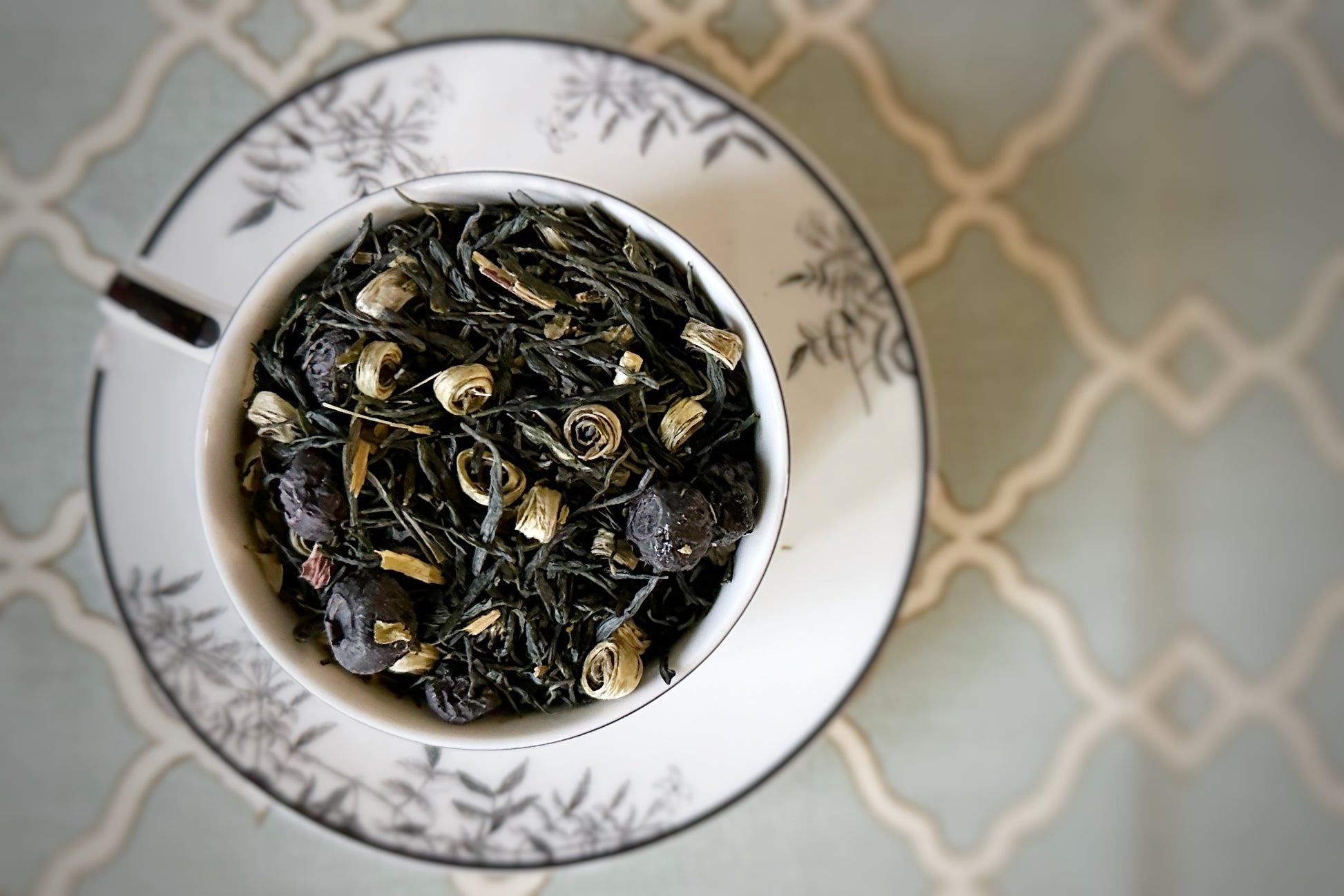 teacup full of green tea and blueberries