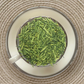 Teacup full of bright green matcha-dusted tea stems