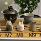 Five slug demon lookin tea pets on a bamboo tea tray