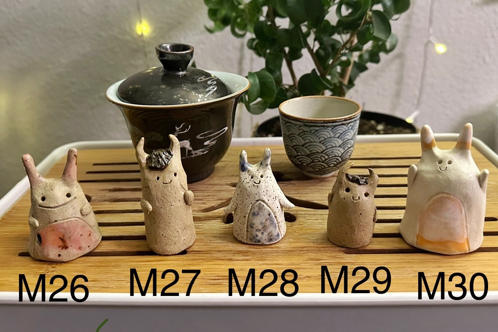 Five slug demon lookin tea pets on a bamboo tea tray