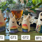 Four grinning horned blob tea pets with rainbow stripes on their bodies numbered ST1, GT1, GT2, BT1